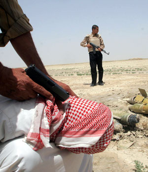 Iraqi police detain a suspect they say was found with a cache of rockets near the southern city of Basra, 550 kms south of Baghdad, 23 April 2006 (AFP)