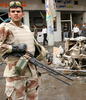 An Iraqi soldier secures the scene of a car bomb, April 24, 2006, in Baghdad, Iraq (AP)