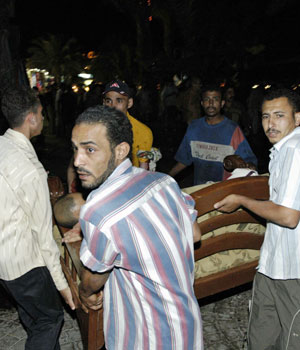 Rescuers carry an injured victim after three explosions shook the Egyptian Red Sea resort of Dahab, April 24, 2006 (REUTERS)