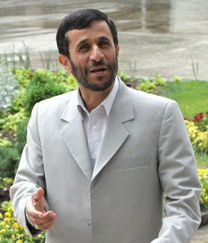 Iranian President Mahmoud Ahmadinejad speaks to photographers while waiting for his Sudanese counterpart Omar al-Bashir during a farewell ceremony in Tehran, 26 April 2006 (AFP)