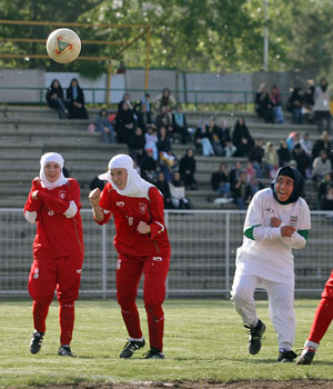 Players from Iran's women national football team (white) fight for the ball with players from Germany's Al-Dersimspor team during a friendly match at Tehran's Ararat stadium 28 April 2006 (AFP)
