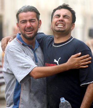 Iraqis mourn the death of a loved one, killed in a bomb explosion in front of the court building in Palestine Street, eastern Baghdad, 4 May 2006 (EPA)