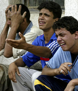 Iraqis cry outside a hospital after their father was among those killed in a bomb attack near a courthouse in Baghdad May 4, 2006 (REUTERS)