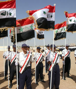 New Iraqi police graduates carry flags during their graduation ceremony in Najaf, 160 km (100 miles) south of Baghdad May 11, 2006 (REUTERS)