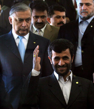 Iranian President Mahmoud Ahmadinejad, front right, waves to journalists as he walks with Pakistani Prime Minister Shaukat Aziz, left, shortly after the opening ceremony of the Developing Eight (D-8) Summit in Bali, Indonesia, May 13, 2006 (AP)