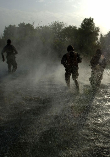 US soldiers and Iraqi troops move out after landing in a flooded field near Tikrit (R)