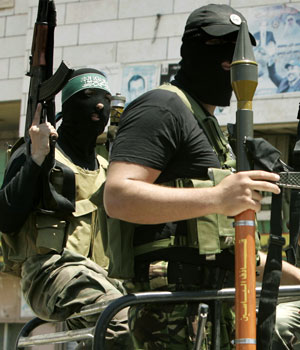 Palestinian militants from Hamas, that are not part of a new security force of the Hamas-led Palestinian government, display their weapons as they drive in the streets of Gaza City, May 17 2006 (AP)