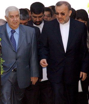 Syrian Foreign Minister Walid al-Moallem (L) with his Iranian counterpart Manouchehr Mottai, who flew in Syria as part of a regional tour which he has begun in Jordan, 18 May 2006 (EPA)