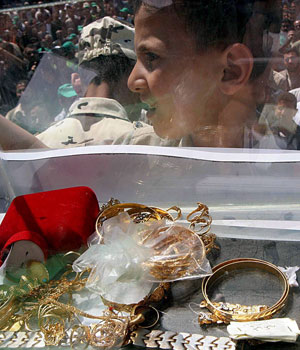 Jewellery and items of value donated by Palestinian Hamas supporters in an effort to raise money are seen in a box outside a mosque after Friday noon prayers in Gaza City, 19 May 2006 (EPA)