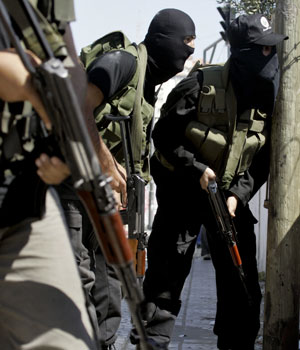 Members of the new security force of the Hamas-led government take cover during a shootout with Palestinian police loyal to Palestinian President Mahmoud Abbas in Gaza City, May 22, 2006 (AP)
