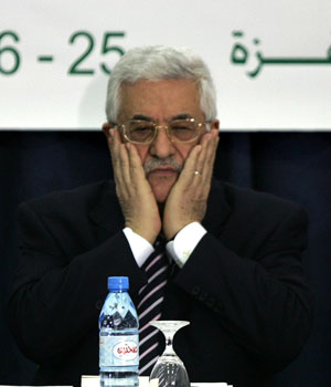 Palestinian President Mahmoud Abbas finishes reciting a prayer at the start of the national dialogue conference with leaders from different political parties at his Muqataa headquarters in the West Bank town of Ramallah, 25 May 2006 (AFP)
