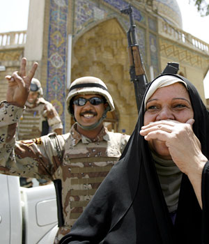 An Iraqi ululates in joy as an Iraqi soldier flashes the "V" sign minutes after hearing Iraqi Prime Minister Nuri al-Maliki announcing 08 June 2006 the death of al-Qaeda leader in Iraq Abu Musab al-Zarqawi (AFP)