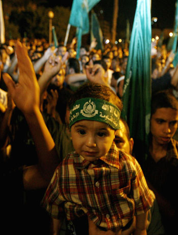 Hamas supporters attend a rally against Israeli air strikes in Gaza (R)