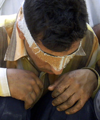 Suspected Iraqi insurgent sits with 22 others inside Iraqi military camp in Baquba (R)