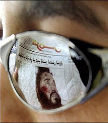 The image Abu Musab al-Zarqawi published on the front page of an Iraqi newspaper is reflected in the sunglasses of an Iraqi civilian in central Baghdad (AFP)