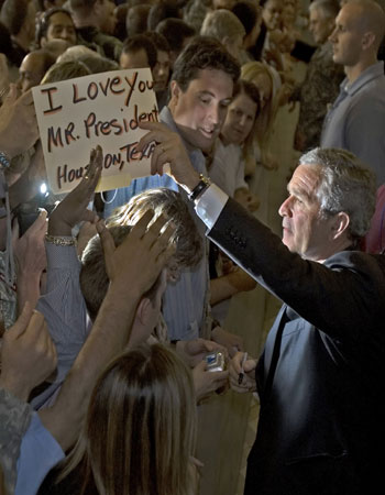 US President George W. Bush reaches out to shake hands with troops and US Embassy employees (AFP)