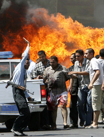 Iraqi residents help a victim to a police vehicle after a car bomb attack in Baghdad (R)