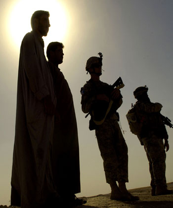 Iraqi commuters looking on as US soldiers search vehicles during an aerial traffic control point north of Baghdad (AFP)
