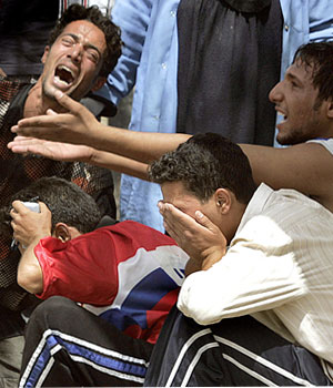 Iraqi youths mourn the death of a relative outside a local hospital in Baghdad, 17 June 2006 (AFP)