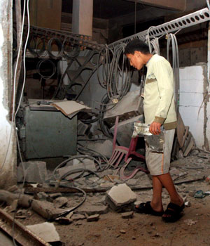 A Palestinian inspects the rubble after a metal workshop was hit by an Israeli helicopter air strike in Gaza City, early Tuesday, 20 June 2006 (EPA)
