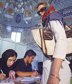 An Iranian woman registers before casting her vote at a mosque transferred into a polling station (AFP)