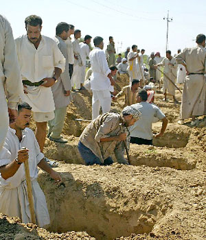 Iraqis prepare graves to bury their relatives who were killed by coalition forces outside the restive city of Baquba, 20 June 2006 (AFP)