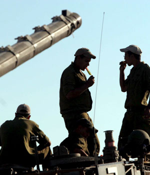 Israeli Defence Force soldiers enjoy ice cream on a tank as troops gather near the border with Gaza late Monday, 26 June 2006 (EPA)