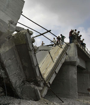 Palestinians inspect a bridge destroyed by Israeli army warplanes on a main road in the northern Gaza Strip, near Gaza City, June 28, 2006 (AP)