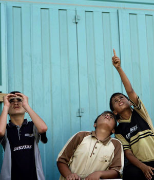 Palestinian boys peer into the sky as an Israeli plane overflies the Rafah refugee camp, southern Gaza Strip, June 29, 2006 (AP)