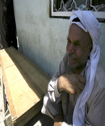 A relative sits outside the Ali Imam hospital and mourns the death of a family member killed in a massive car bomb blast early (AP)