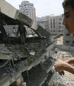 A boy looks at the destroyed Palestinian Interior Ministry which was targeted during an early morning Israeli air raid in Gaza City, 05 July 2006 (AFP)