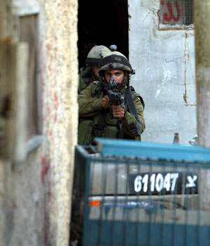 Israeli soldiers run to take up positions during an army operation following the killing of Palestinian militant Tamer Qandil 21, a member  of Al-Aqsa Martyrs' Brigades militant group, in the Askar Refugee Camp near Nablus, 7 July 2006 (EPA)