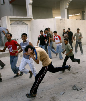 Palestinians run for cover as Israeli troops open fire in the area of Beit Lahiya, northern Gaza Strip, July 6, 2006 (AP)