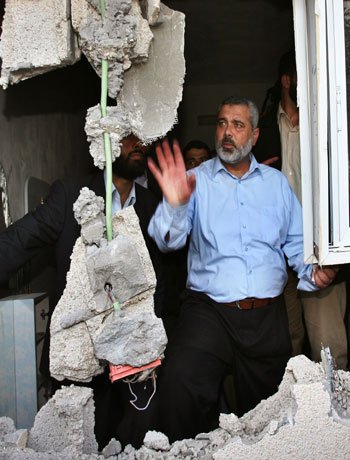 Palestinian Prime Minister Ismail Haniyeh checks the damage at a Palestinian house after the Israeli withdrew in North Gaza (R)