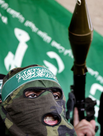 Abu Obayda, a spokesman for Hamas' armed wing the Ezzedine al Qassam Brigades wears a camouflage hood during a press conference (AFP)
