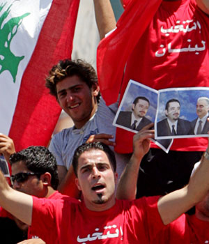 Lebanese supporters of slain former prime minister Rafik al-Hariri raise posters of him and his son Saad al-Hariri during a celebration in the streets of Tripoli in northern Lebanon June 19, 2005 (REUTERS)