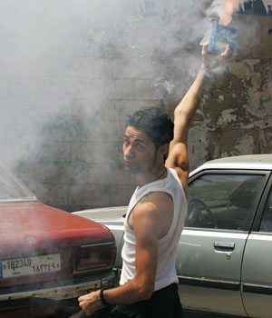 A Lebanese man holds a firecracker in his hand as he celebrates in Beirut, Lebanon, after Hezbollah captured two Israeli soldiers near the border with Israel, 12 July 2006 (AP)