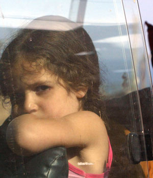 A girl sits in a car with her family as they flee the Israeli attacks on south Lebanon in Damour July 15, 2006 (REUTERS)