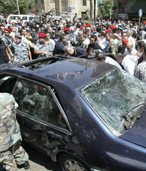 Lebanese security forces, journalists and onlookers gather around the damaged car of Lebanon's former Communist Party chief George Hawi following his assassination near his home in a Beirut residential neighbourhood 21 June 2005 (AFP)