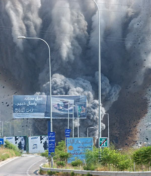 Smoke rises and debris flies from a bridge as it is targeted by an Israeli air raid, in the Zahrani region, on the Mediterranean coast, southern Lebanon, July 14, 2006 (AP)