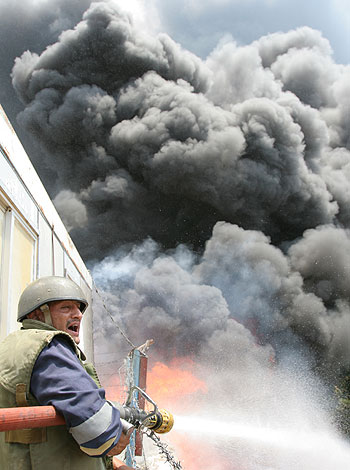 A fire fighter works while smoke rises from a factory after it was struck by an Israeli warplane missile at the outskirts of southern Lebanon (AP)