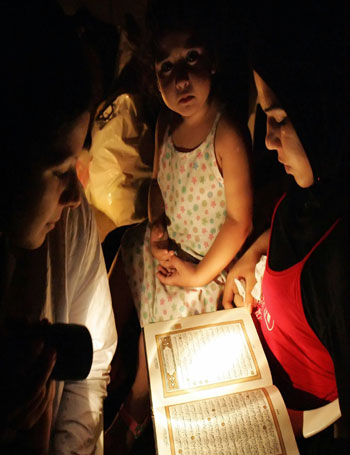 A Muslim Lebanese family reads the holy Quran in a bomb shelter (AFP)