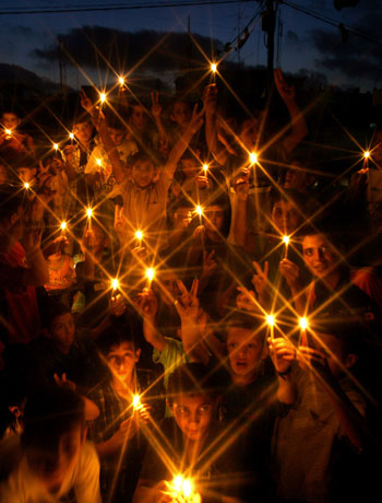 Palestinian children demonstrate with candles in a square in Jabalya refugee camp(AFP)