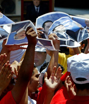 Lebanese supporters of slain former prime minister Rafik al-Hariri raise posters of him and his son Saad al-Hariri during a celebration in northern Lebanon June 19, 2005 (REUTERS)