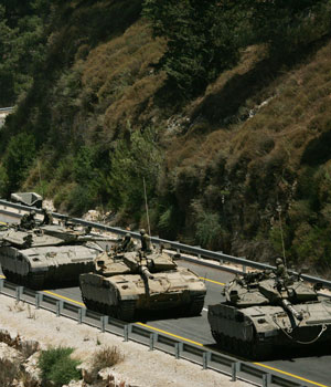 A convoy of Israeli tanks prepares to enter southern Lebanon near the northern Israeli village of Avivim, July 19, 2006 (AP)
