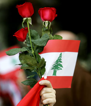 A man carries roses and a Lebanese flag during a protest against Israel's military offensive in Lebanon outside of the United Nations Organization (ONU) in Mexico City, Mexico, July 20, 2006 (AP)