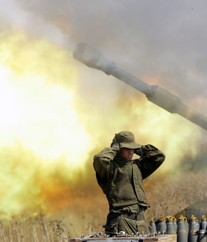 An Israeli soldier covers his ears as a mobile artillery unit fires a 155mm shell towards Hezbollah targets in southern Lebanon, 21 July 2006, Kiryat Shmona along the northern Israeli border with Lebanon (AFP)