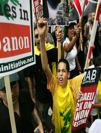A boy draped in a Hezbollah flag cries out as he joins protesters marching through central London (AP)