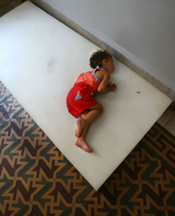 A Lebanese child sleeps on the floor of a school in Beirut, Lebanon (R)