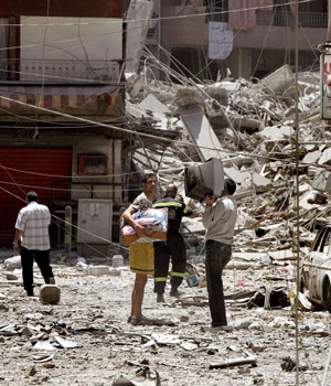 A Lebanese family carry belongings in a street in the Hezbollah stronghold of south of Beirut, 25 July 2005 (EPA)